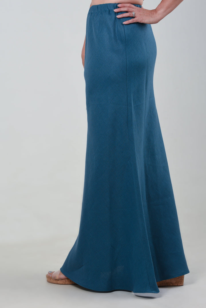Side view of a model wearing a teal maxi skirt