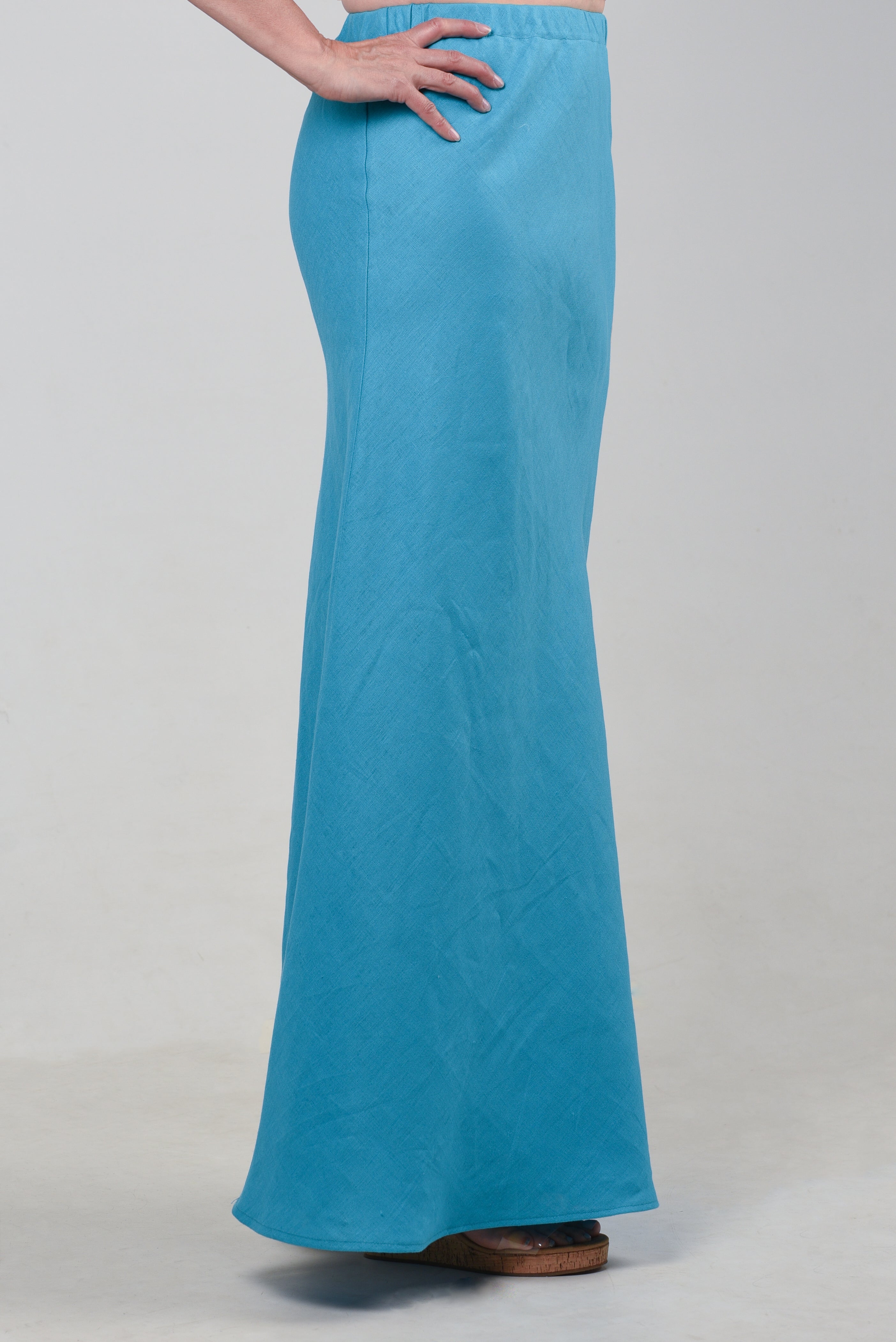 Side view of a model wearing a turquoise maxi skirt