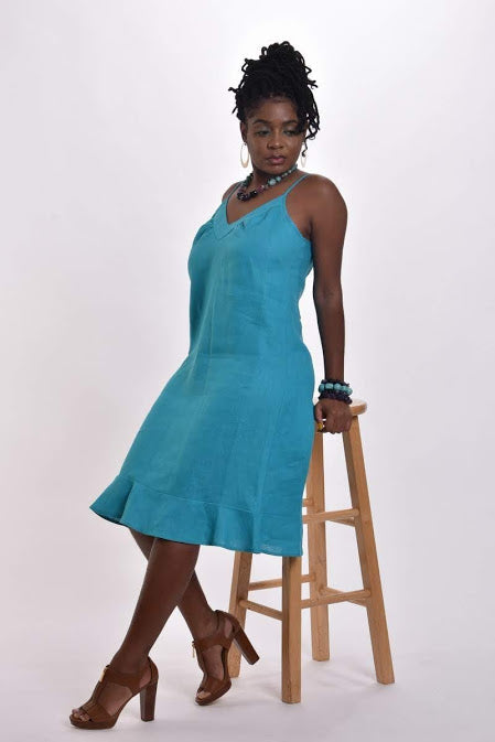 Woman in a turquoise linen flounce dress with spaghetti straps
